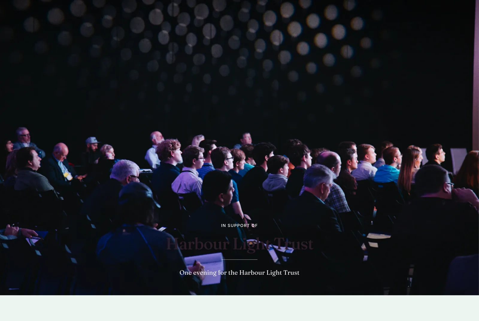 The opening of a fundraiser page: an audience in a dark hall, and over it the words in support of Harbour Light Trust.